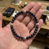 Bracelet perles d'eau douce Black Tahiti et argent 925 présenté dans une main ouverte.