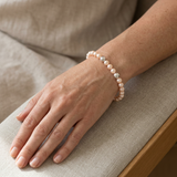 Bracelet en argent 925 et perles d'eau douce roses porté au poignet.