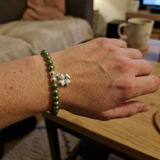 Bracelet perles vertes argent 925 avec charm trèfle porté au poignet.