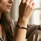 Bracelet perles noires argent 925 porté au poignet, fermoir anneau visible.