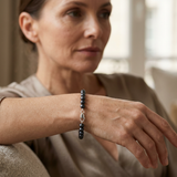 Bracelet perles noires argent 925 avec fermoir mousqueton porté au poignet.