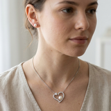 Collier et boucles d'oreilles à perles blanches portés sur cou et oreille, pendentif cœur orné de zircons.