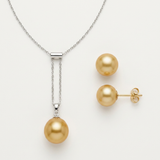 Collier pendentif et boucles d'oreilles puces ornés d'une perle dorée sur fond neutre.